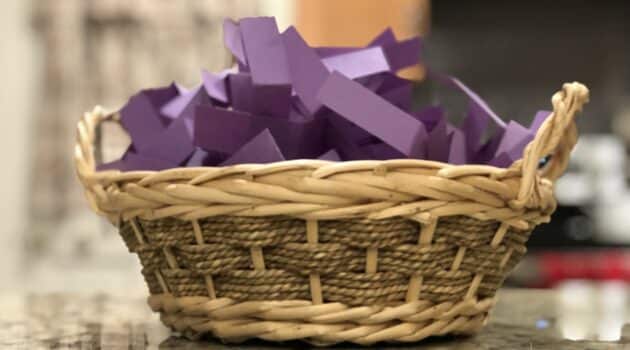 A basket of purple slips of paper sits on a counter