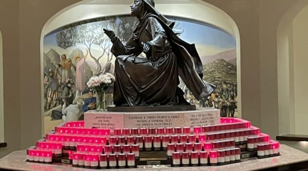 St Rita statue surrounded by red candles