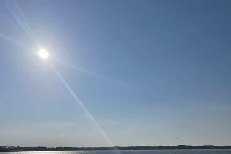 Rays come from the sun in a blue sky